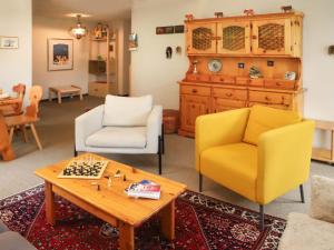 uma sala de estar com duas cadeiras e uma mesa em Apartment Chalet Simmental P-3 by Interhome em Zweisimmen
