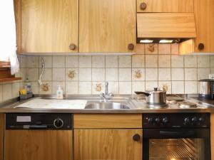 uma cozinha com um lavatório e um fogão em Apartment Chalet Simmental P-3 by Interhome em Zweisimmen