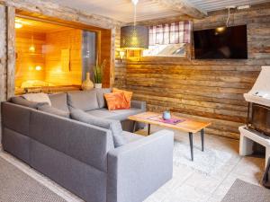 ein Wohnzimmer mit Sofa und Tisch in der Unterkunft Holiday Home Uuttuniemi by Interhome in Kuusamo