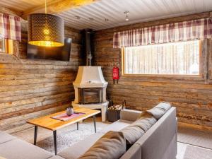 a living room with a couch and a stove at Holiday Home Uuttuniemi by Interhome in Kuusamo
