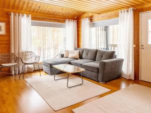 ein Wohnzimmer mit Sofa und Tisch in der Unterkunft Holiday Home Uuttuniemi by Interhome in Kuusamo