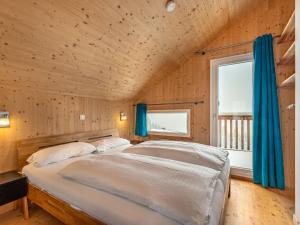 1 dormitorio con 1 cama grande y cortinas azules en Chalet Klippitzoase by Interhome, en Klippitztorl