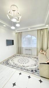 un salon avec un canapé et une télévision dans l'établissement # 51 Светлая квартира в ЖК Лагуна, à Atyraū