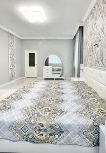 une pièce vide avec un grand tapis sur le sol dans l'établissement # 51 Светлая квартира в ЖК Лагуна, à Atyraū