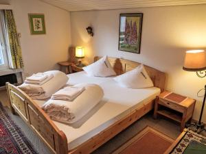 una camera con 2 letti con lenzuola e cuscini bianchi di Apartment Utoring Acletta-155 by Interhome a Disentis