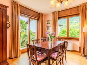 a dining room with a wooden table and chairs and windows at Apartment Bruna by Interhome in Gera Lario