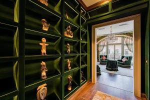 Habitación con paredes verdes y estatuas en la pared. en Celine Residence Luxury en Budapest