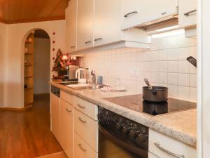 uma cozinha com um fogão e um lavatório em Apartment Marie-Soleil Est by Interhome em Gstaad