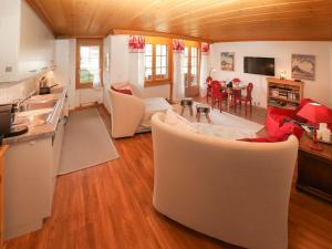 een woonkamer met witte meubels en een keuken bij Apartment Marie-Soleil Est by Interhome in Gstaad