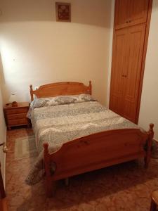 a bedroom with a wooden bed in a room at Casa Milagros in Mirambel