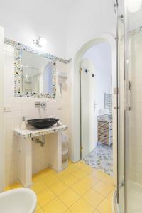 ein Bad mit einem Waschbecken und einem Spiegel in der Unterkunft Mediterranea Casa del Capricorno in Massa Lubrense