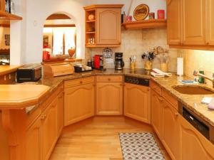 cocina grande con armarios de madera y fregadero en Apartment Marie-Soleil Sud by Interhome en Gstaad