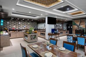 a dining room with a table and a kitchen at Vivanta Jamshedpur, Golmuri in Jamshedpur