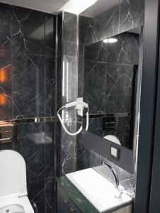 a black tiled bathroom with a toilet and a mirror at Bonita Boutique in Istanbul +17 photos