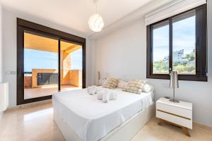 - une chambre blanche avec un grand lit et de grandes fenêtres dans l'établissement CT 182 - Golfer's Paradise, à Mijas