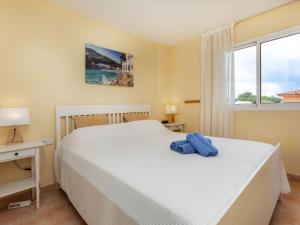 ein Schlafzimmer mit einem weißen Bett und einem Fenster in der Unterkunft Apartment Port Pals A III by Interhome in Pals