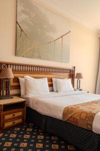 Un pat sau paturi într-o cameră la Om Kalthom Hotel