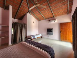 奇克马格尔Rangi Taranga Resort的一间卧室，里面有一张床和一台平板电视