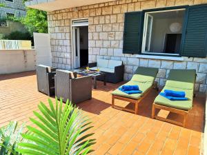 un patio con 2 sillas, una mesa y una mesa en Villa Blue Promenade, en Dubrovnik