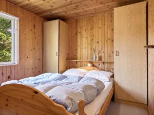 um quarto com uma cama numa parede de madeira em Holiday Home Anne - 150m from the sea in SE Jutland by Interhome em Børkop