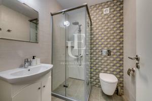 a bathroom with a shower and a toilet and a sink at Vienna A lovely two bedrooms apartment with parking in Sofia +10 photos