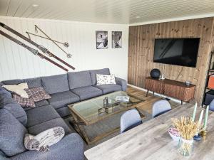 a living room with a couch and a tv at Chalet Kosetoppen - SOW145 by Interhome in Fossdal