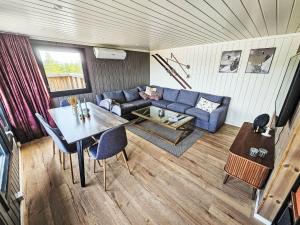 a living room with a blue couch and a table at Chalet Kosetoppen - SOW145 by Interhome in Fossdal