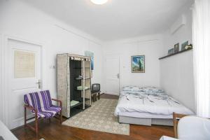 ein Schlafzimmer mit einem Bett und einem Stuhl darin in der Unterkunft Nick's Old Town Apartment in Labin