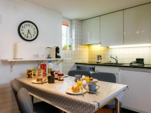 a kitchen with a table with food and a clock at Apartment Villaggio Sureggio - App- C1 by Interhome in Lugaggia +37 photos