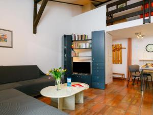 a living room with a couch and a table at Apartment Villaggio Sureggio - App- C1 by Interhome in Lugaggia