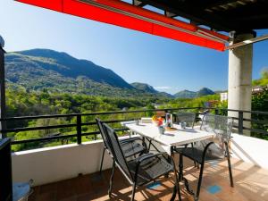 a table and chairs on a balcony with a view at Apartment Villaggio Sureggio - App- C1 by Interhome in Lugaggia