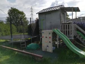 een speeltuin met een glijbaan en een speelhuis bij Notre nid d'amour in Saint-Sernin-du-Bois