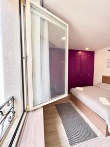 a bedroom with a bed and a large window at MODERNO APPARTAMENTO IN Piazza SAN GIACOMO in Udine