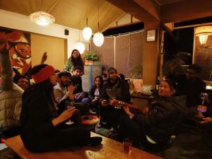 un groupe de personnes assises dans une pièce dans l'établissement Mellow Fellow Hostel, à Gangtok