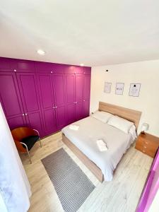 a bedroom with a large bed with purple walls at MODERNO APPARTAMENTO IN Piazza SAN GIACOMO in Udine