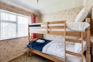 キドリントンにあるKidlington 3 BR House with parking & large gardenの二段ベッド2台と窓のある寝室