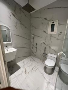 biała łazienka z toaletą i umywalką w obiekcie سرايا الخليجية w mieście Al-Hufuf