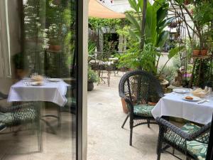 una mesa con un mantel blanco y una mesa con sillas en Aux Augustins Palais des Papes & Fitness, en Aviñón