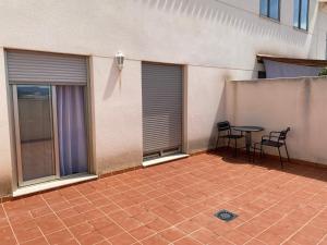 a patio with a table and chairs next to a building at Apartamento San Vicente in Villar del Arzobispo