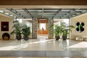 a lobby with potted plants in a building at Daios Cove in Agios Nikolaos