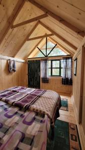 1 dormitorio con 1 cama en una habitación de madera en Eco Camp Drno Brdo, en Kosanica