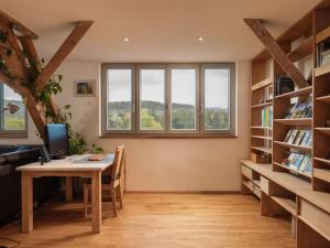 ein Büro mit einem Schreibtisch, Bücherregalen und einem Fenster in der Unterkunft Apartment Altes Zollhaus-3 by Interhome in Fischbach