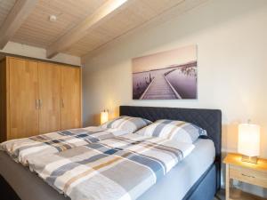 a bedroom with a bed with a picture on the wall at Apartment Nachtigall II-3 by Interhome in Osten