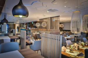 un restaurante con mesas de madera, sillas y luces en Hotel Seven en Villach