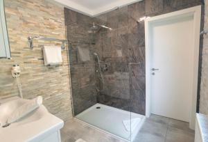 uma casa de banho com um chuveiro e uma porta de vidro em Hotel Kärntnerhof & SeeBlick Suiten em Presseggersee