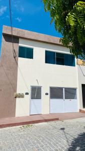 a white building with two garage doors on it at Aconchego na Capital do Forró - Térreo in Caruaru