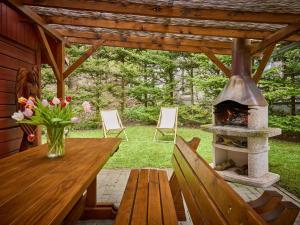 a patio with a wooden table and a fireplace at Apartment Stříbrný pramen-1 by Interhome in Janske Lazne
