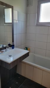 a bathroom with a sink and a bath tub at Maison 24h du Mans in Arnage