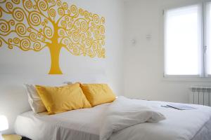 a bed with a tree stenciled on a wall at Casadamare in Lido di Jesolo