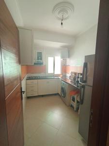 a small kitchen with a refrigerator and a dishwasher at المضيق 